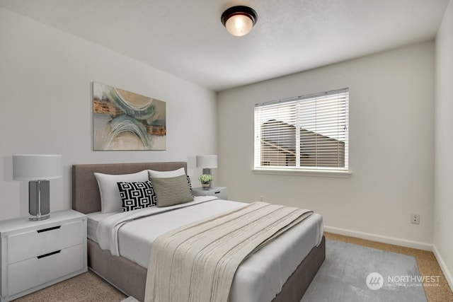 bedroom with light colored carpet and baseboards