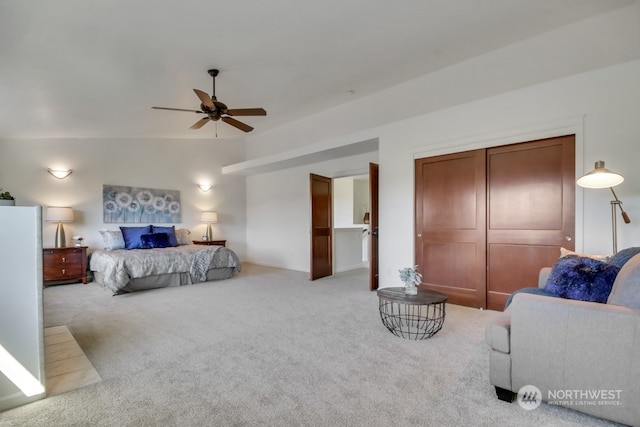 bedroom with a ceiling fan, a closet, and light colored carpet