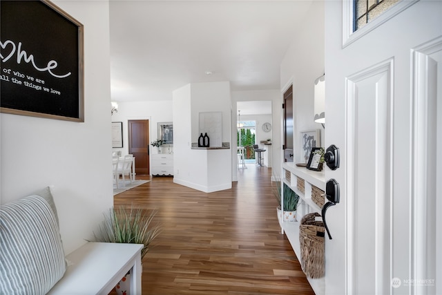 corridor featuring baseboards and wood finished floors