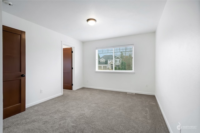 unfurnished room featuring baseboards and light colored carpet