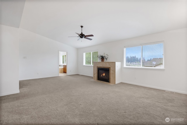 unfurnished living room featuring a tile fireplace, ceiling fan, light carpet, and vaulted ceiling