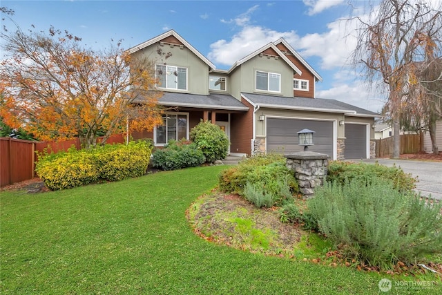 view of front of home featuring driveway, a garage, fence, and a front yard