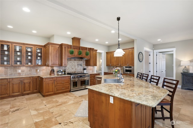 kitchen with sink, decorative light fixtures, a large island, a kitchen bar, and stainless steel appliances