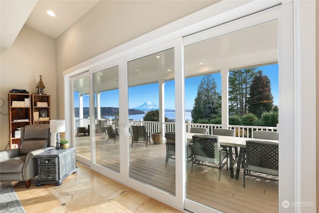 doorway to outside with a water and mountain view and a healthy amount of sunlight