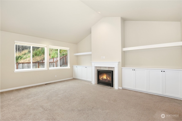 unfurnished living room with light colored carpet and vaulted ceiling