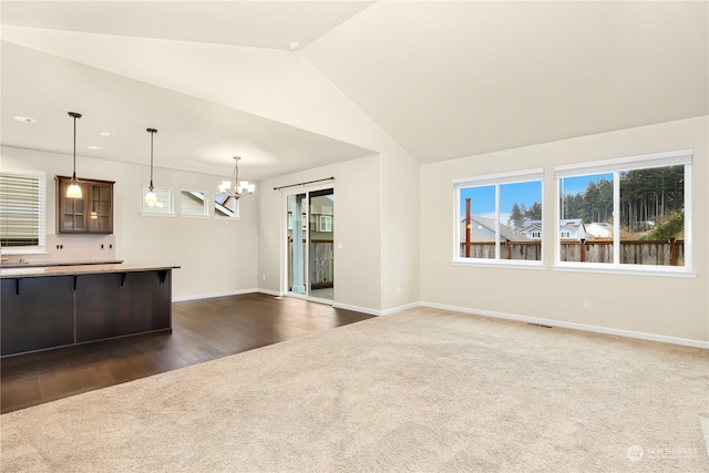 kitchen featuring pendant lighting, a kitchen bar, lofted ceiling, dark hardwood / wood-style flooring, and a chandelier