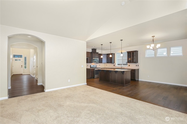 kitchen featuring a center island, dark wood-type flooring, decorative light fixtures, dark brown cabinets, and stainless steel appliances