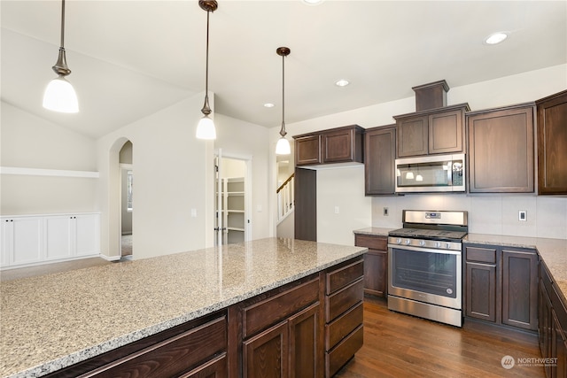 kitchen with pendant lighting, dark hardwood / wood-style flooring, light stone counters, and stainless steel appliances