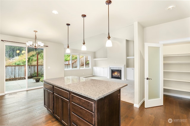 kitchen featuring light stone countertops, dark wood-type flooring, and decorative light fixtures