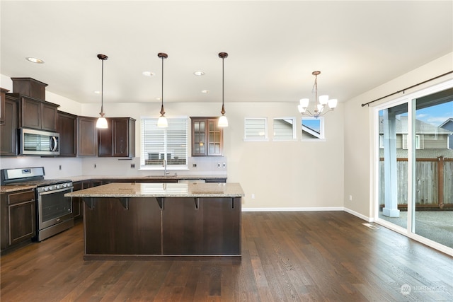 kitchen featuring plenty of natural light, dark hardwood / wood-style floors, light stone countertops, and appliances with stainless steel finishes