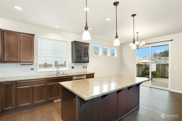 kitchen with light stone counters, plenty of natural light, and dark wood-type flooring