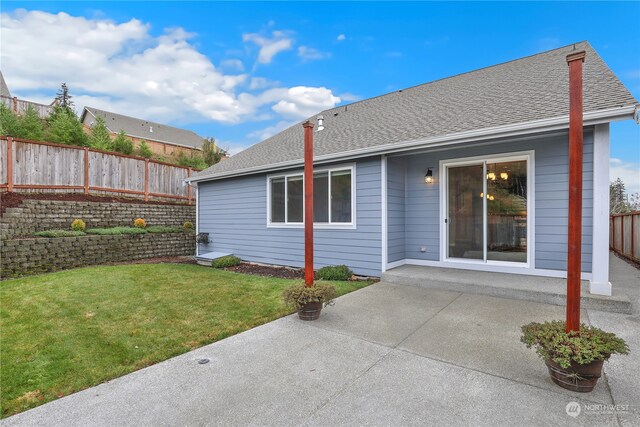 rear view of house featuring a yard and a patio