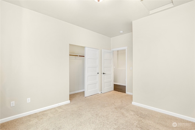 unfurnished bedroom with light carpet and a closet