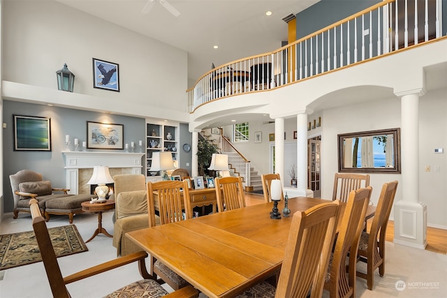 dining space featuring built in features, a towering ceiling, and ornate columns