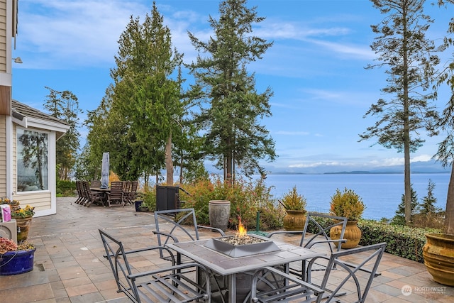 view of patio with a water view and an outdoor fire pit