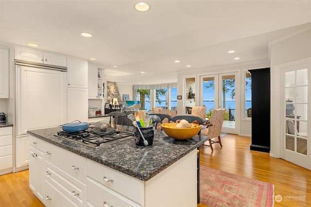 kitchen featuring a kitchen island, white cabinets, light hardwood / wood-style floors, and stainless steel gas cooktop