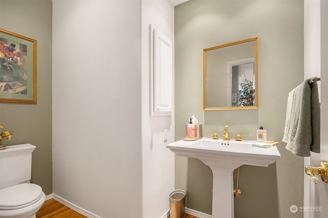 bathroom with wood-type flooring and toilet