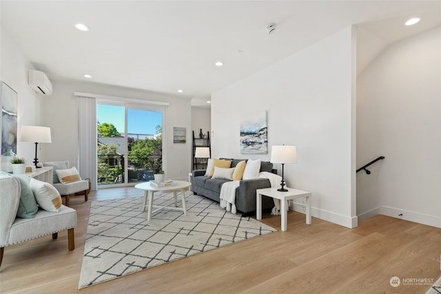 living room with a wall mounted air conditioner and light hardwood / wood-style floors