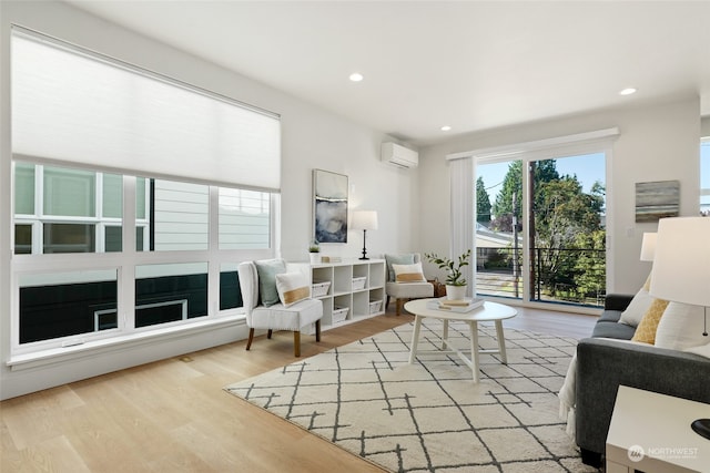 living room featuring light hardwood / wood-style floors and a wall mounted AC