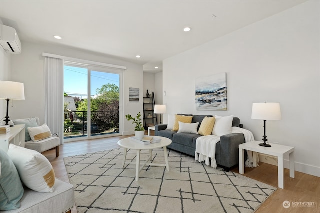 living room featuring a wall mounted air conditioner and light hardwood / wood-style flooring