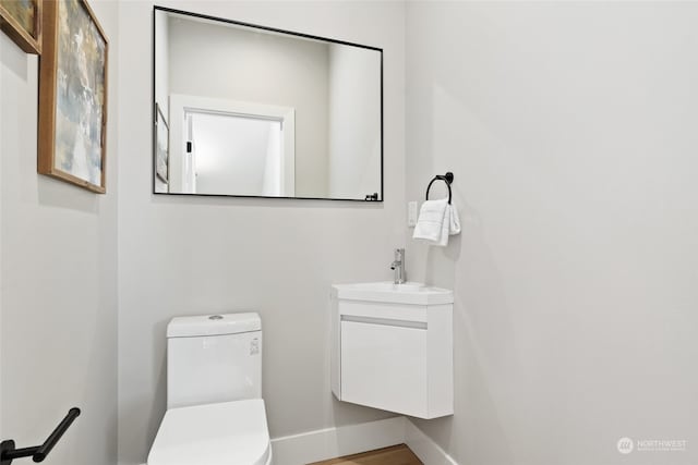 bathroom featuring hardwood / wood-style floors, vanity, and toilet