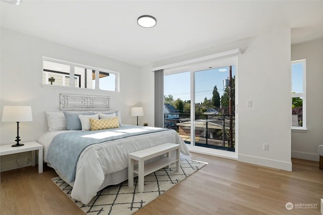 bedroom with access to exterior and light hardwood / wood-style floors