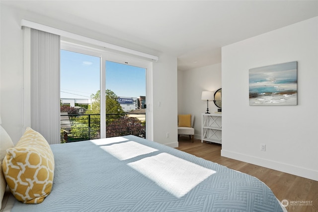 bedroom with access to outside and hardwood / wood-style floors