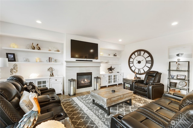 living room featuring a tile fireplace and hardwood / wood-style floors