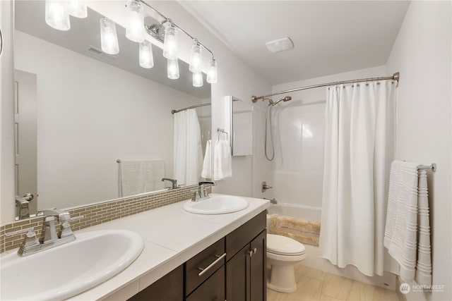 full bathroom with tasteful backsplash, tile patterned flooring, toilet, vanity, and shower / tub combo