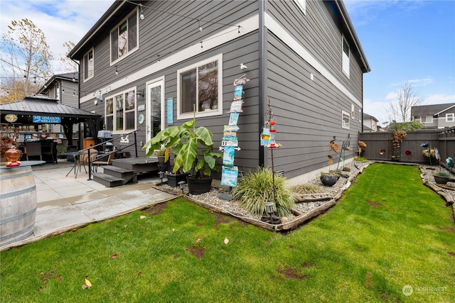 rear view of house with a gazebo, a patio area, and a lawn