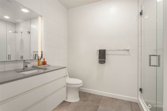 bathroom with walk in shower, tile patterned floors, toilet, tile walls, and vanity