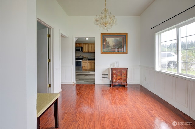 unfurnished dining area with dark hardwood / wood-style floors and a notable chandelier