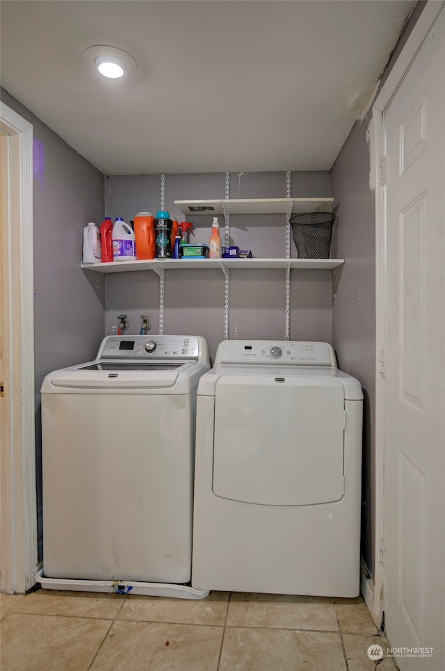 clothes washing area with washer and clothes dryer and light tile patterned floors