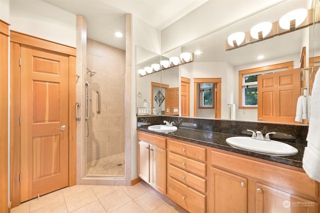 bathroom featuring tile patterned flooring, vanity, and a shower with door