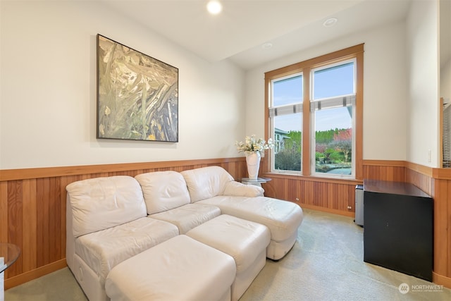 carpeted living room with wood walls