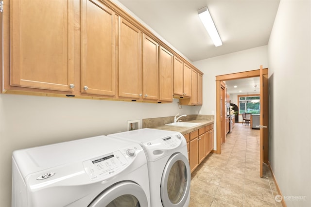 laundry room featuring cabinets, sink, and washing machine and dryer