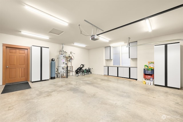 garage with secured water heater and a garage door opener