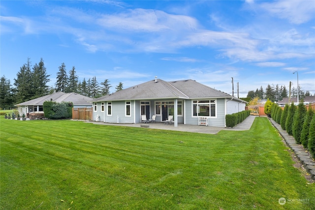 back of house with a patio area and a yard