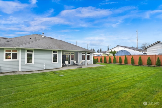 back of property featuring a lawn and a patio