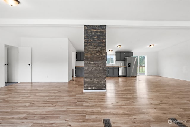 unfurnished living room featuring ornate columns and light hardwood / wood-style flooring