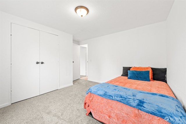 bedroom featuring light colored carpet and a closet