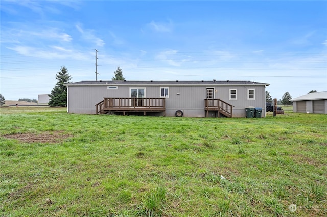 back of property featuring a wooden deck and a lawn