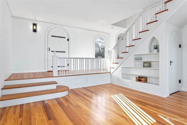 stairway featuring built in shelves and hardwood / wood-style flooring