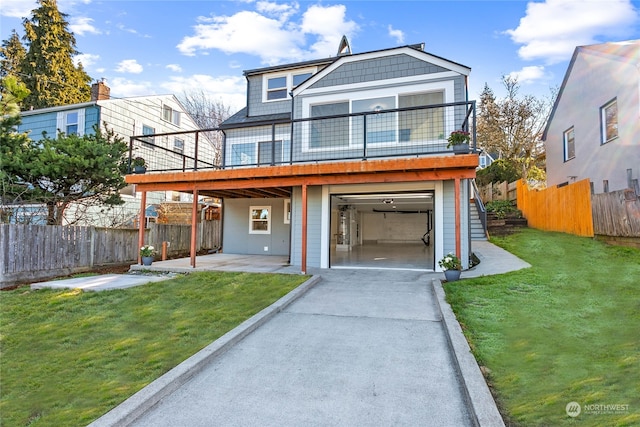 view of front of home featuring a garage, a front lawn, and a deck