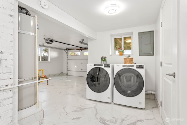 washroom with electric panel, washer and dryer, and gas water heater