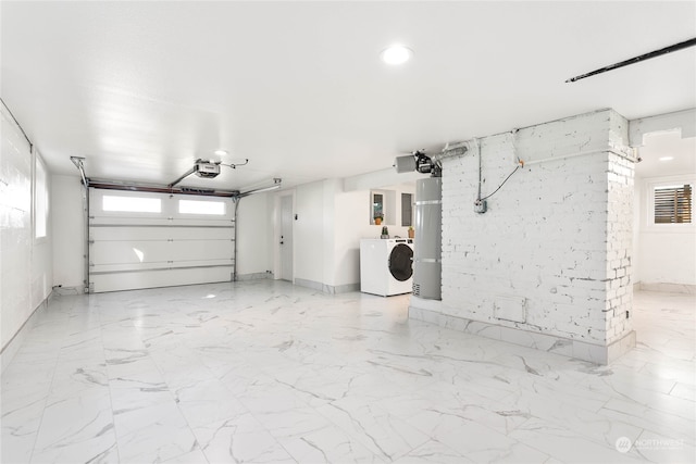 garage with strapped water heater, a garage door opener, and washer / dryer