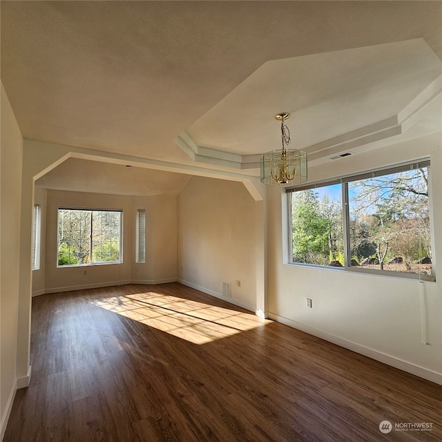 spare room featuring hardwood / wood-style flooring, a notable chandelier, and a tray ceiling