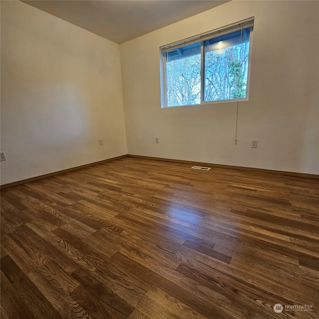 spare room with dark hardwood / wood-style flooring