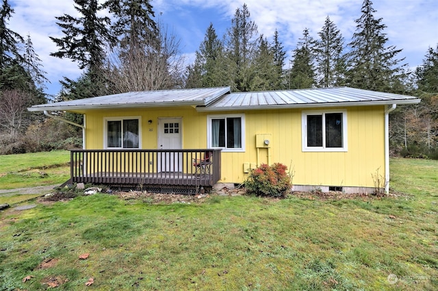 view of front of home with a front yard and a wooden deck