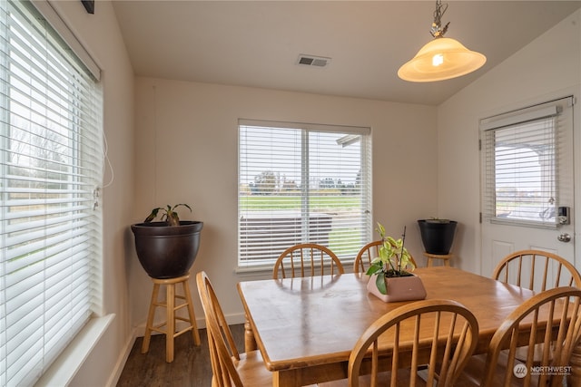 dining room with dark wood-type flooring and lofted ceiling